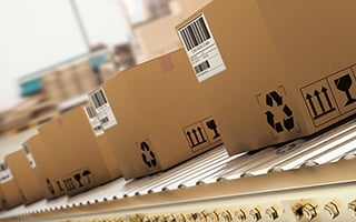 Cardboard boxes on a rolling conveyor belt.