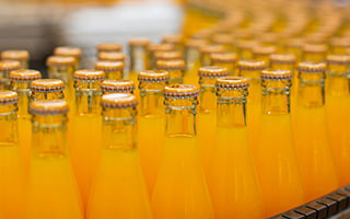 Filled soda bottles being moved on a conveyor belt.